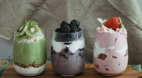 Trzy desery w szklankach: zielony z kiwi, fioletowy z jeżynami i różowy z truskawkami. Idealne na dietę South Beach.