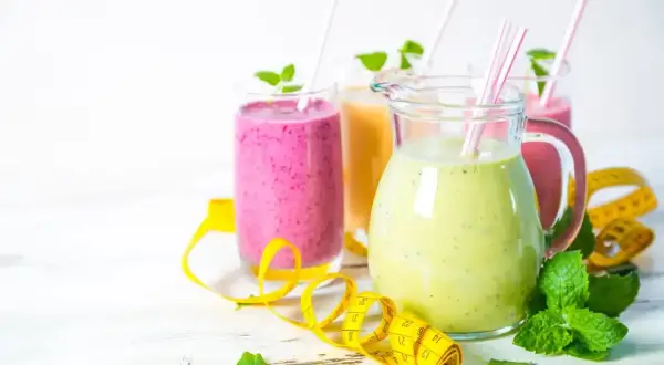 Kolorowe smoothie, w tym koktajl z ananasa, z miętą i miarką, idealne na zdrową dietę.