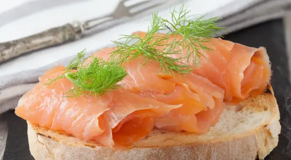 Kanapka z wędzonym łososiem i koperkiem. Czy łosoś wędzony jest zdrowy? Tak, to pyszna i bogata w kwasy omega-3 przekąska.