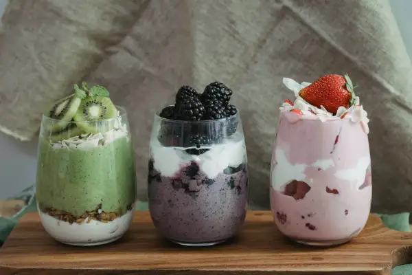 Trzy desery w szklankach: zielony z kiwi, fioletowy z jeżynami i różowy z truskawkami. Idealne na dietę South Beach.