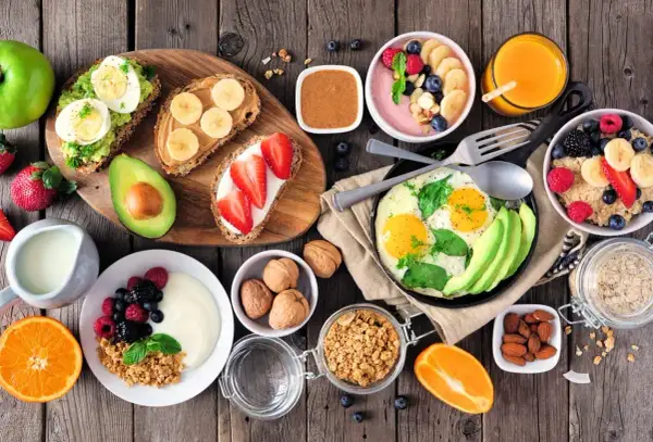 Różnorodne, zdrowe śniadanie: tosty z awokado i jajkiem, owsianka, jogurt z owocami, jajecznica, smoothie bowl.
